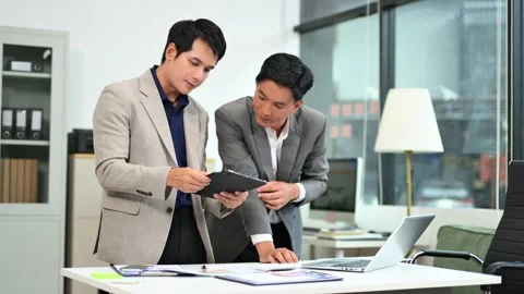 Two business workers talking on the smartphone and using laptop Stock Footage 312714813