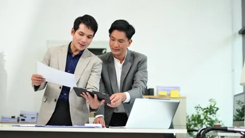 Two business workers talking on the smartphone and using laptop Stock Footage 312714815