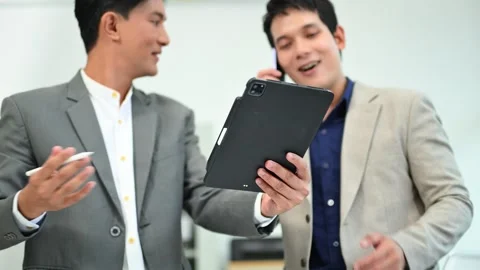Two business workers talking on the smartphone and using laptop Stock Footage 312714829