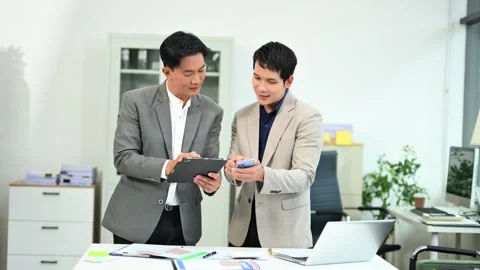 Two business workers talking on the smartphone and using laptop Stock Footage 312714832