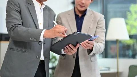 Two business workers talking on the smartphone and using laptop Stock Footage 312714841