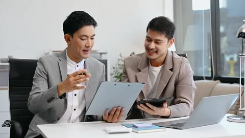 Two business workers talking on the smartphone and using laptop at the office Video stock 312980692