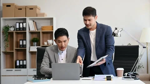 Two business workers talking on the smartphone and using laptop at the office Stock Footage 312980733