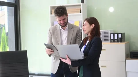 Two business workers talking on the smartphone and using laptop Video stock 312981706