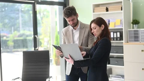 Two business workers talking on the smartphone and using laptop Video stock 312981724