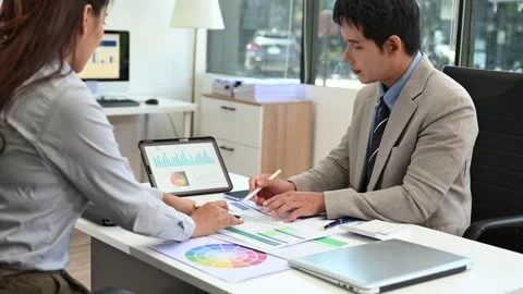 Two business workers talking on the smartphone and using laptop at the office Stock Footage 313461358