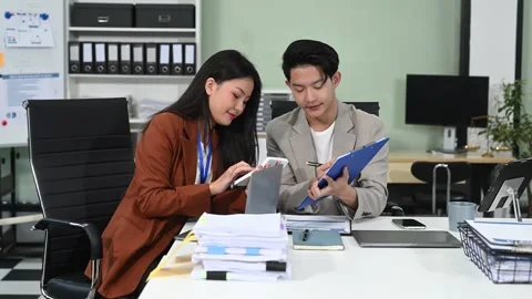 Two business workers talking on the smartphone and using laptop at office. Stock Footage 313706265