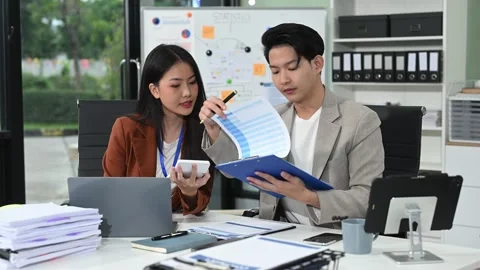 Two business workers talking on the smartphone and using laptop at office. Stock Footage 313706272