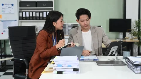 Two business workers talking on the smartphone and using laptop at office. Stock Footage 313706279