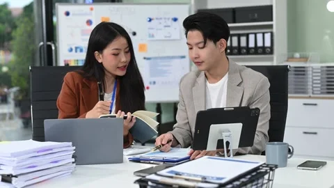 Two business workers talking on the smartphone and using laptop at office. Stock Footage 313706289