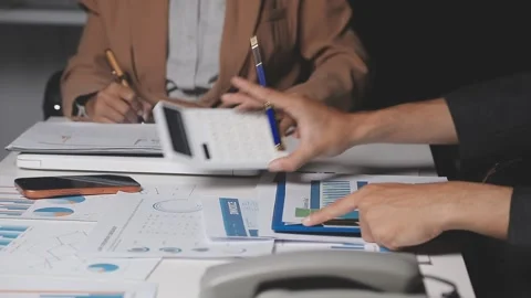 Two Businessman Calculating Bills Using Calculator At Workplace. Business t.. Stock Footage 328997442