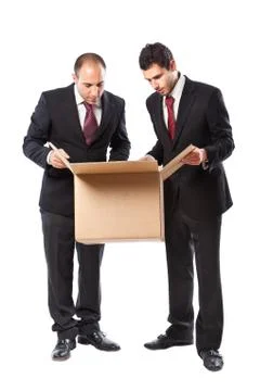 Two businessman looking inside a box Stock Photos