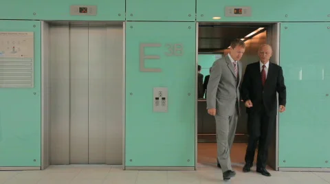 Two businessman out of elevator TWO TAKES Stock Footage 492250