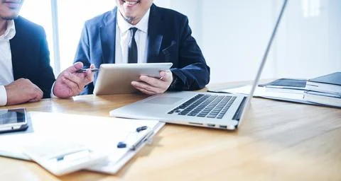 Two businessman using digital tablet and laptop discussing ideal at meeting . Stock-Fotos