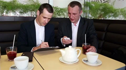 Two businessman writes data from smartphone in a documents 스톡 동영상 64753943