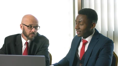Two businessmen actively gesturing and discussing an important project at a Stock Footage 91821509