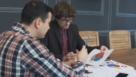 Two businessmen analyze the graphs Stock Footage 86489381
