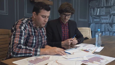 Two businessmen analyze the graphs Stock Footage 86490401