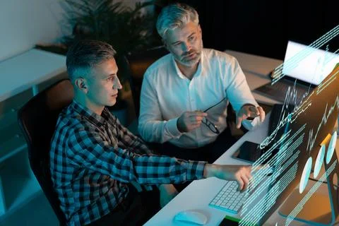 Two Businessmen Analyzing Data and Strategies on Computer Screen Stock Photos