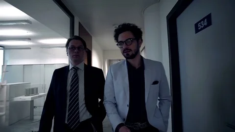 Two businessmen are going through a corridor of the business center. Front view. Stock Footage 70171270