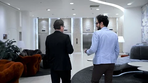 Two businessmen are going through a elevator hall of the business hotel. Back. Stock Footage 70171420