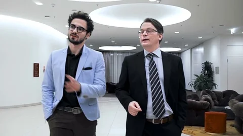 Two businessmen are going through a hall of the business hotel. Slow motion Stock Footage 70171446