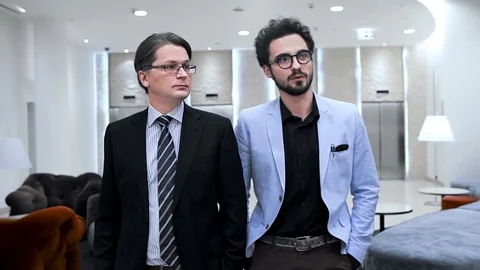 Two businessmen are going through a hall of the business hotel. Close. Slow. Stock Footage 70171585