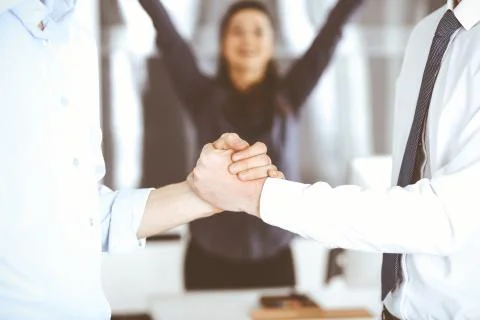 Two businessmen are shaking hands in office, close-up. Happy and excited Stock Photos