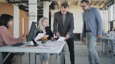 Two businessmen are walking around the office, chatting, approaching employees Stock Footage 108938896