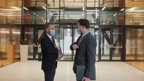 Two businessmen avoid a handshake when meeting and greet with elbows bumping. Video stock 151480804