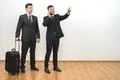 The two businessmen with a bag phone and gesture on the white wall background Photo