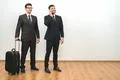 The two businessmen with a bag phone on the white wall background Photo