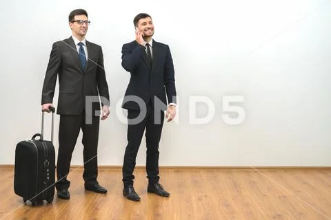 The two businessmen with a bag phone on the white wall background Stock Photos