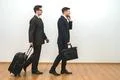The two businessmen with bags phone on the white wall background Photo
