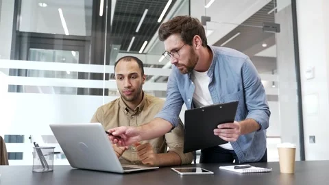 Two businessmen discussing startup project details using laptop in business  Vídeo Stock 338060604