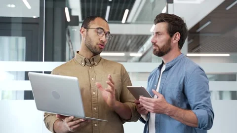 Two businessmen engaged in teamwork while standing in a business office. Vídeo Stock 338057898