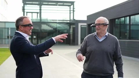 Two businessmen engaging with virtual reality technology outdoors, using VR g Stock-Footage 275860959