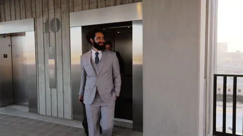 Two Businessmen Exiting Elevator on Rooftop Parking Deck with Concrete Walls and Stock Footage 275967782