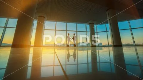 The two businessmen handshake in the office on the sunset background Stock Photos