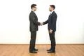 The two businessmen handshake on the white wall background Photo