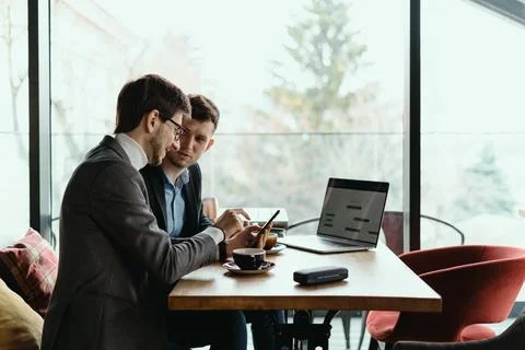 Two businessmen having a conversation using a smartphone Stock Photos