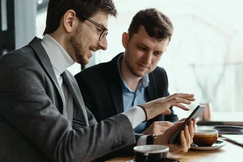 Two businessmen having a conversation using a smartphone Stock Photos