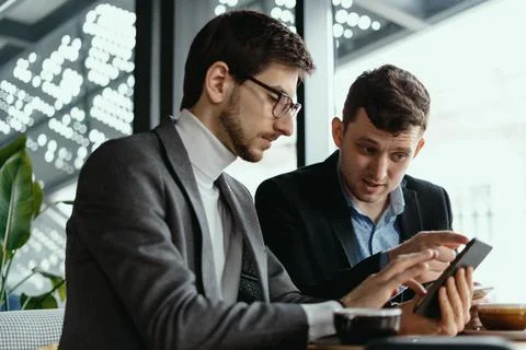 Two businessmen having a conversation using a smartphone Stock Photos