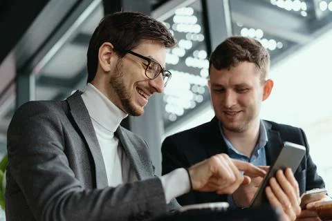 Two businessmen having a conversation using a smartphone Stock Photos