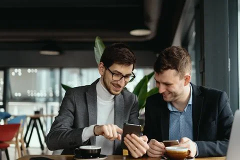 Two businessmen having a conversation using a smartphone Foto stock