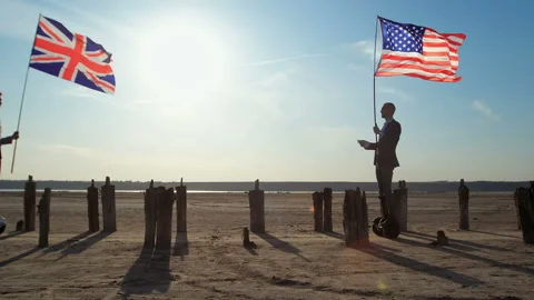 Two businessmen, a hoverboard, flags of the USA and UK. Stockbeeldmateriaal 137950283