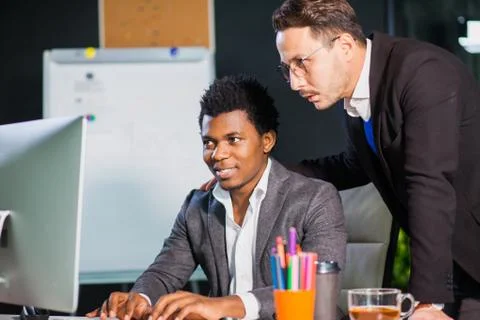 Two businessmen looking at computer screen, teamwork concept. 库存照片