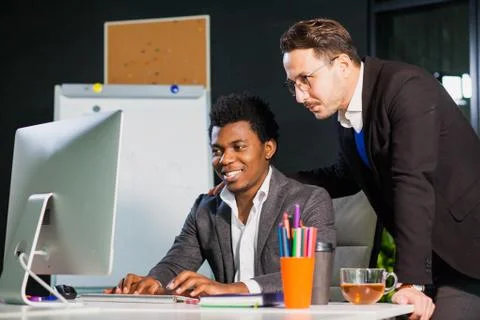 Two businessmen looking at computer screen, teamwork concept. Photos