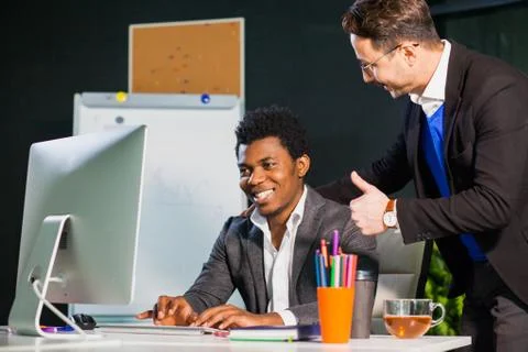 Two businessmen looking at computer screen, teamwork concept. 库存照片