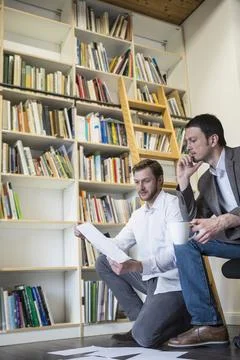 Two businessmen looking at notes in an office, Bavaria, Germany Stock Photos